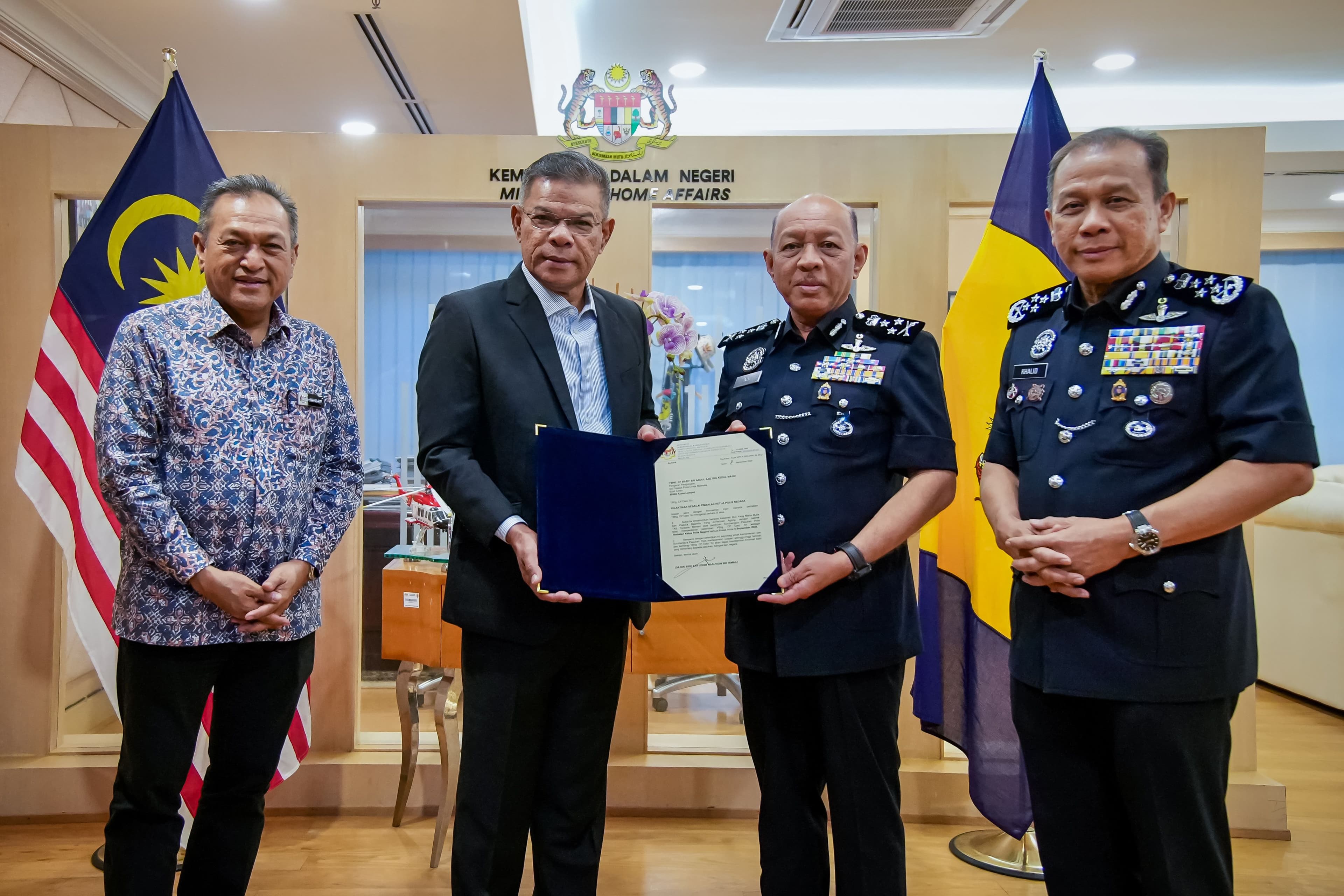 Saifuddin Nasution Ismali menyerahkan watikah pelantikan Timbalan Ketua Polis Negara kepada Abdul Aziz Abdul Majid. - Gambar KDN